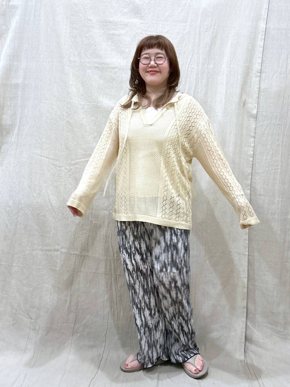 ホワイト系のニット/セーター、ブラック系のその他パンツ、ホワイト系のタンクトップを着用したレディースの夏コーディネートの3枚目の写真