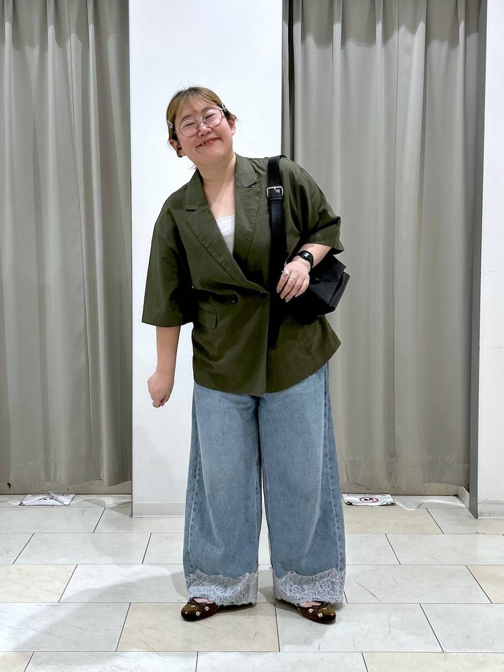 ブルー系のデニムパンツ、ブラック系のショルダーバッグ、ブラウン系のバレエシューズを着用したレディースの夏コーディネートの2枚目の写真