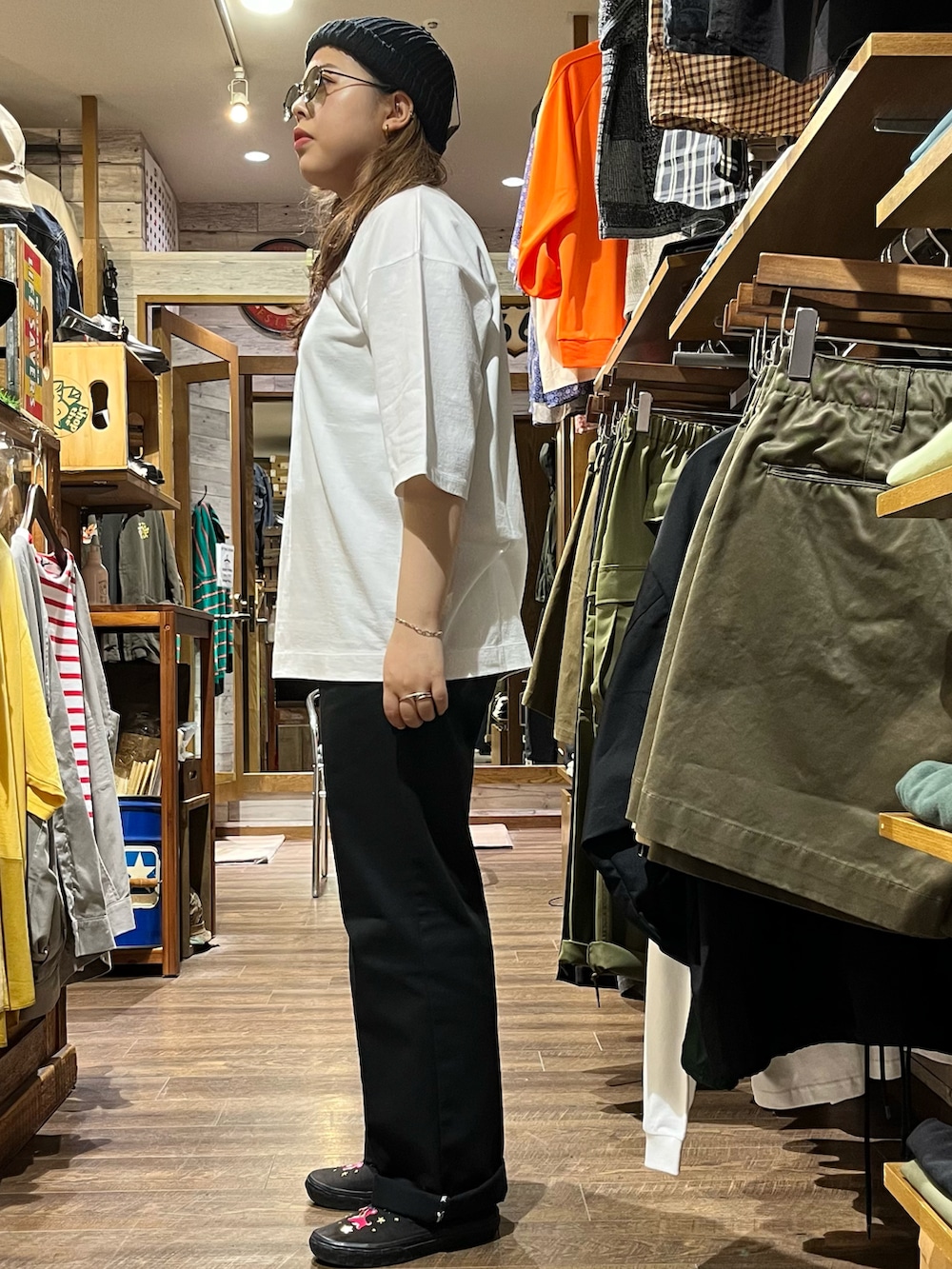 ブラック系のチノパンツ、ホワイト系のTシャツ/カットソー、ブラック系のスリッポンを着用したレディースの夏コーディネートの2枚目の写真