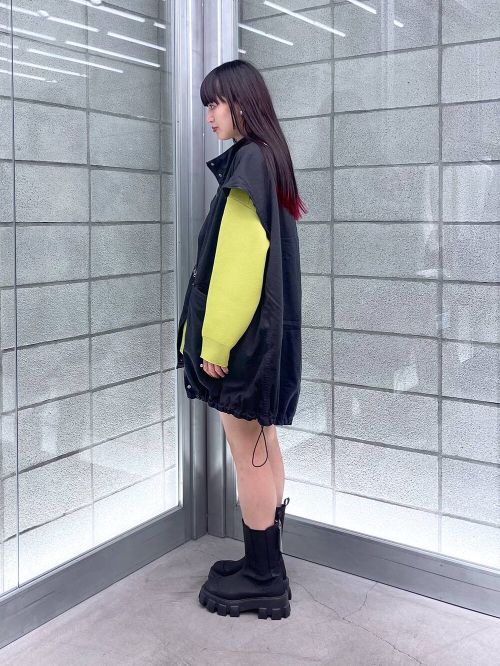 グリーン系のニット/セーター、ブラック系のショルダーバッグ、ブラック系のミリタリージャケットを着用したレディースの秋コーディネートの5枚目の写真