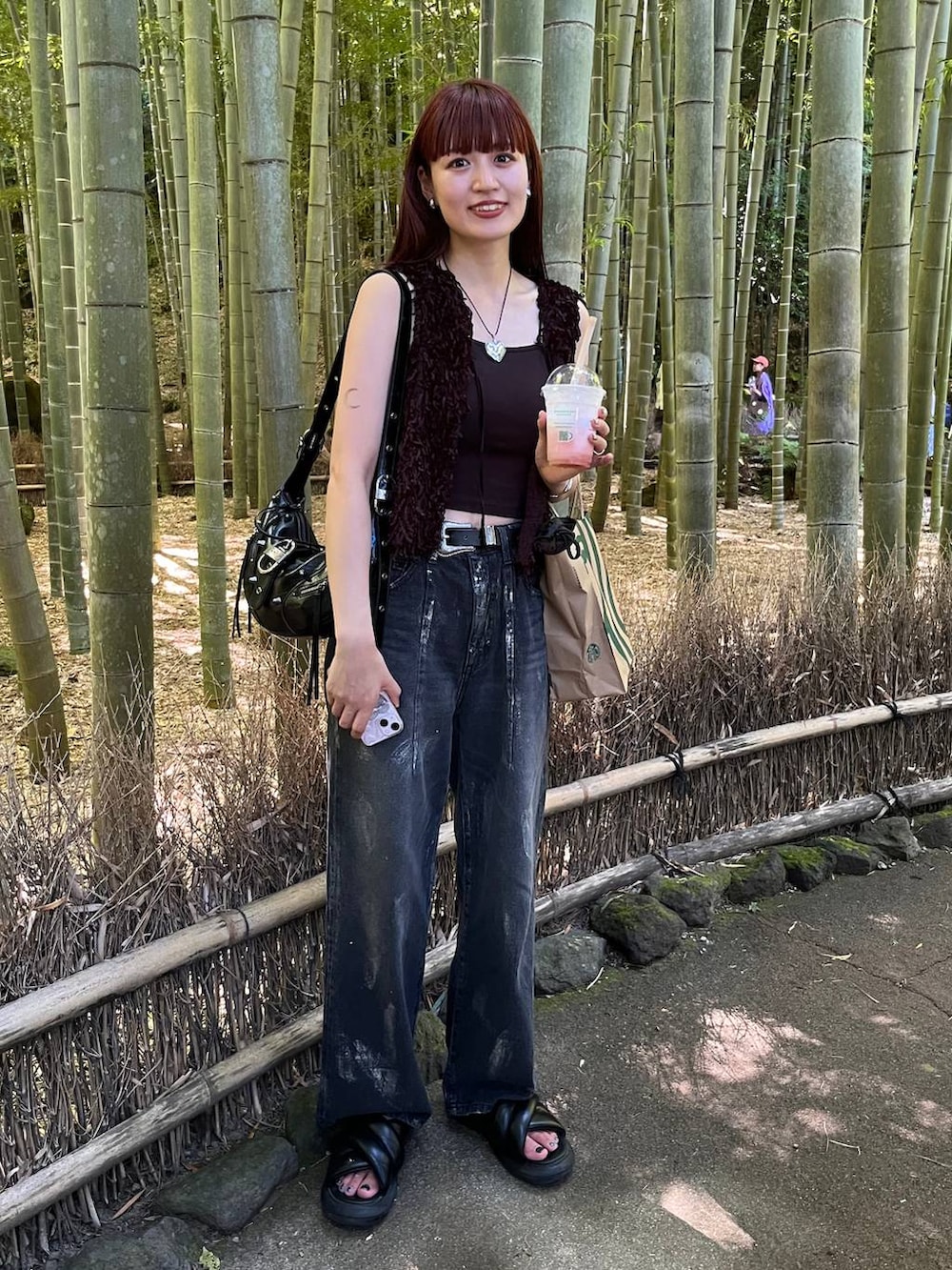 ブラック系のベスト、ブラック系のデニムパンツを着用したレディースの夏コーディネートの6枚目の写真