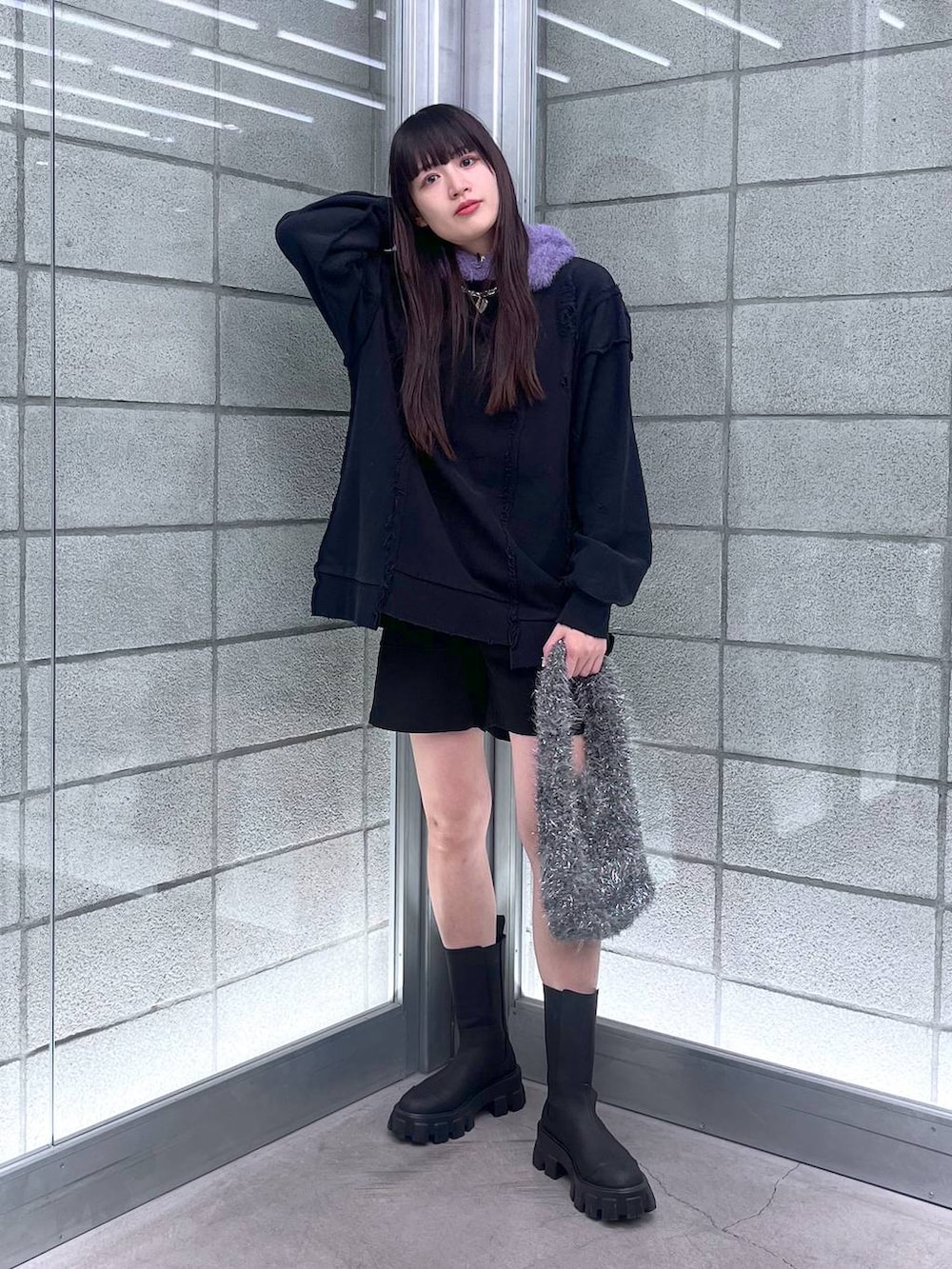 グレー系のハンドバッグ、ブラック系のスウェット、シルバー系のネックレスを着用したレディースの冬コーディネートの7枚目の写真