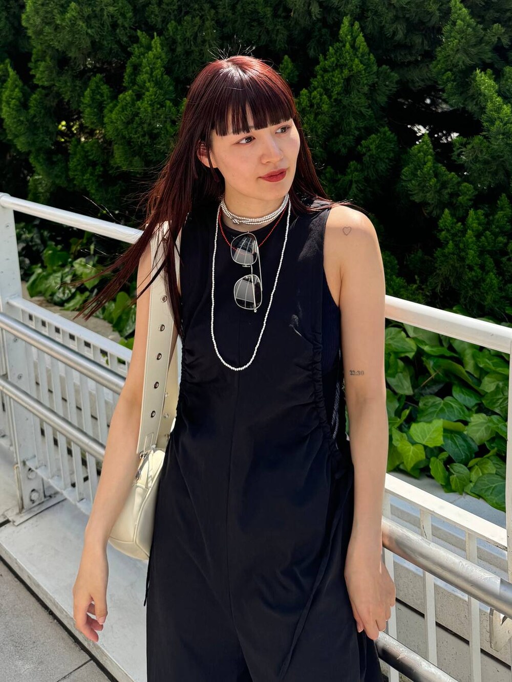 ホワイト系のショルダーバッグ、ブラック系のサロペット/オーバーオール、ブラック系のサンダルを着用したレディースの春コーディネートの4枚目の写真