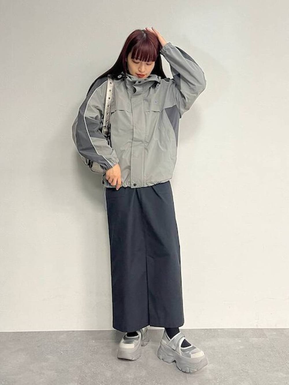 シルバー系のスニーカー、シルバー系のショルダーバッグ、ブラック系のセットアップを着用したレディースの秋コーディネートの3枚目の写真