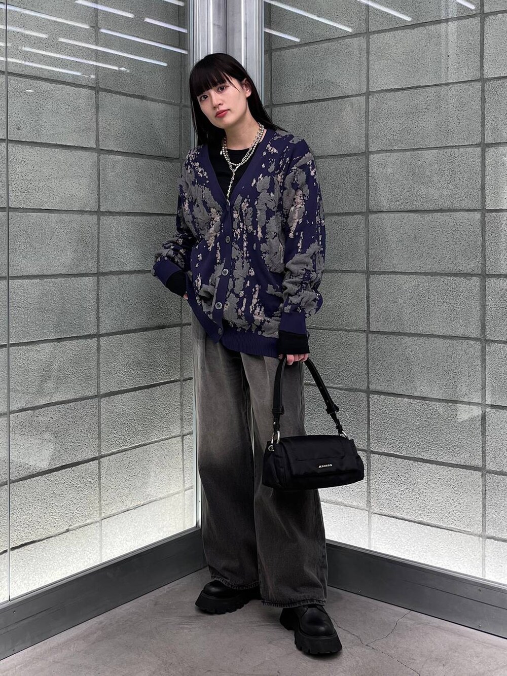 ブルー系のカーディガン/ボレロ、ブラック系のデニムパンツ、ブラック系のショルダーバッグを着用したレディースの冬コーディネートの4枚目の写真