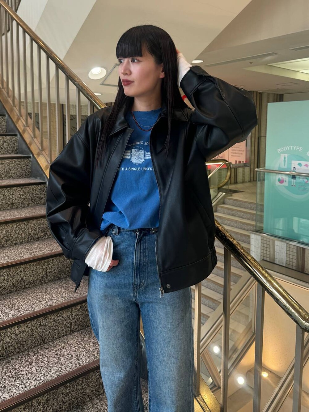 ブラック系のブルゾン、ブルー系のデニムパンツ、ブルー系のTシャツ/カットソーを着用したレディースの冬コーディネートの5枚目の写真