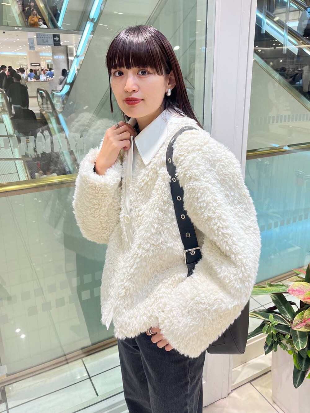 ブラック系のデニムパンツ、ブラック系のショルダーバッグ、ブラック系のブーツを着用したレディースの秋コーディネートの8枚目の写真