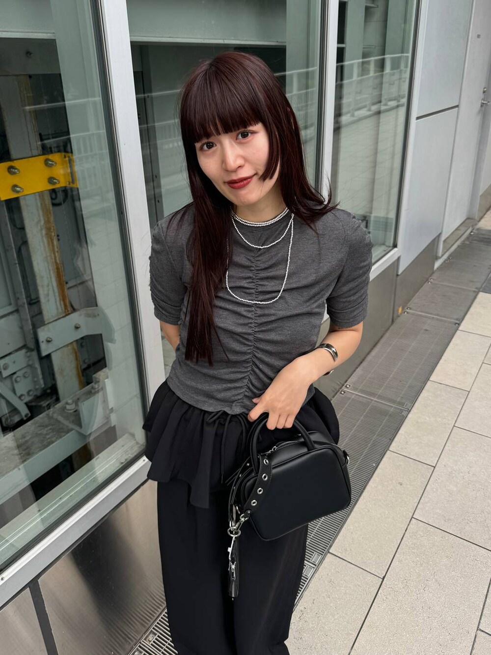 ブラック系のショルダーバッグ、グレー系のTシャツ/カットソー、ブラック系のその他パンツを着用したレディースの夏コーディネートの5枚目の写真