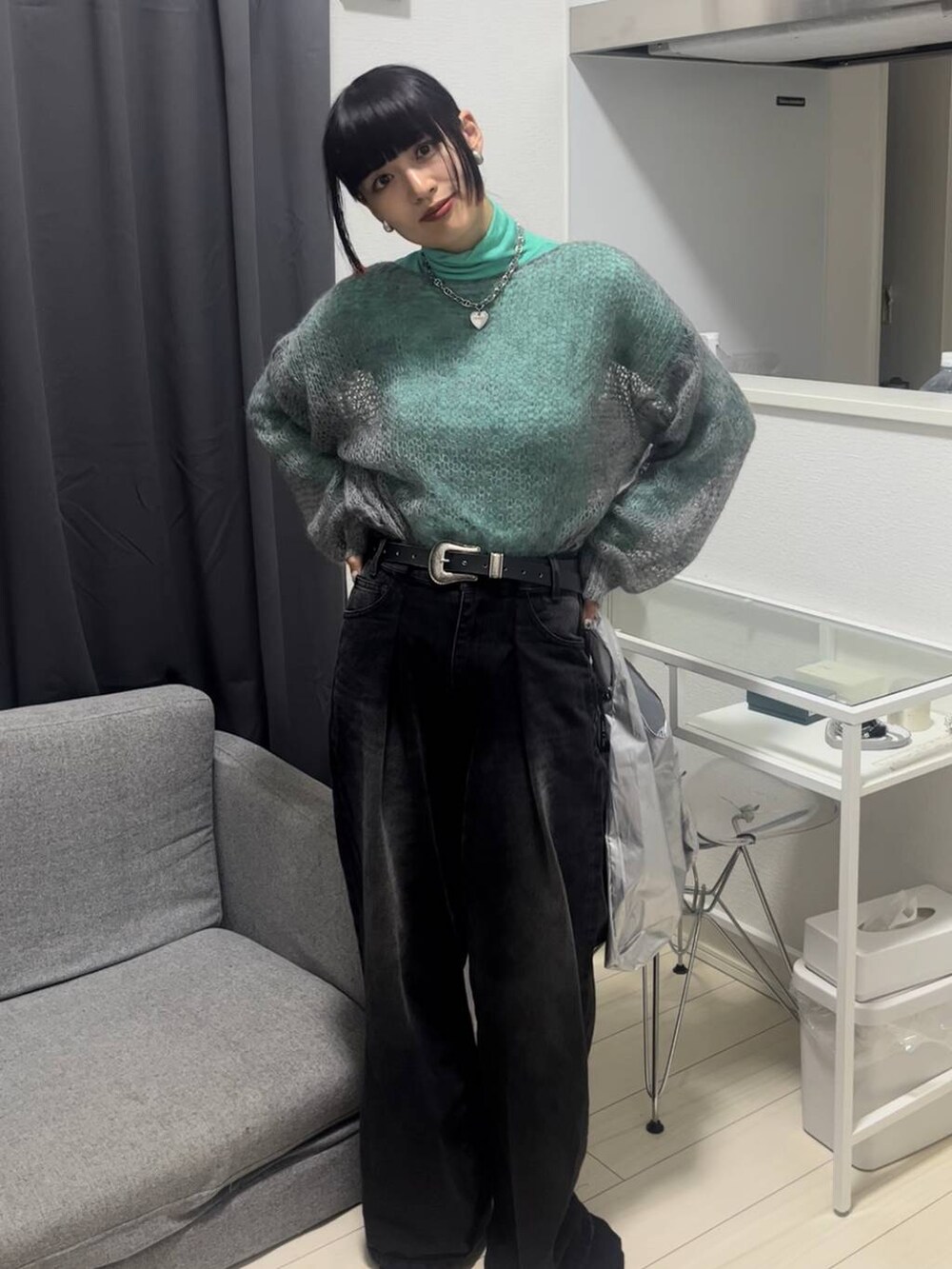 ブラック系のデニムパンツ、グレー系のニット/セーター、シルバー系のネックレスを着用したレディースの秋コーディネートの5枚目の写真