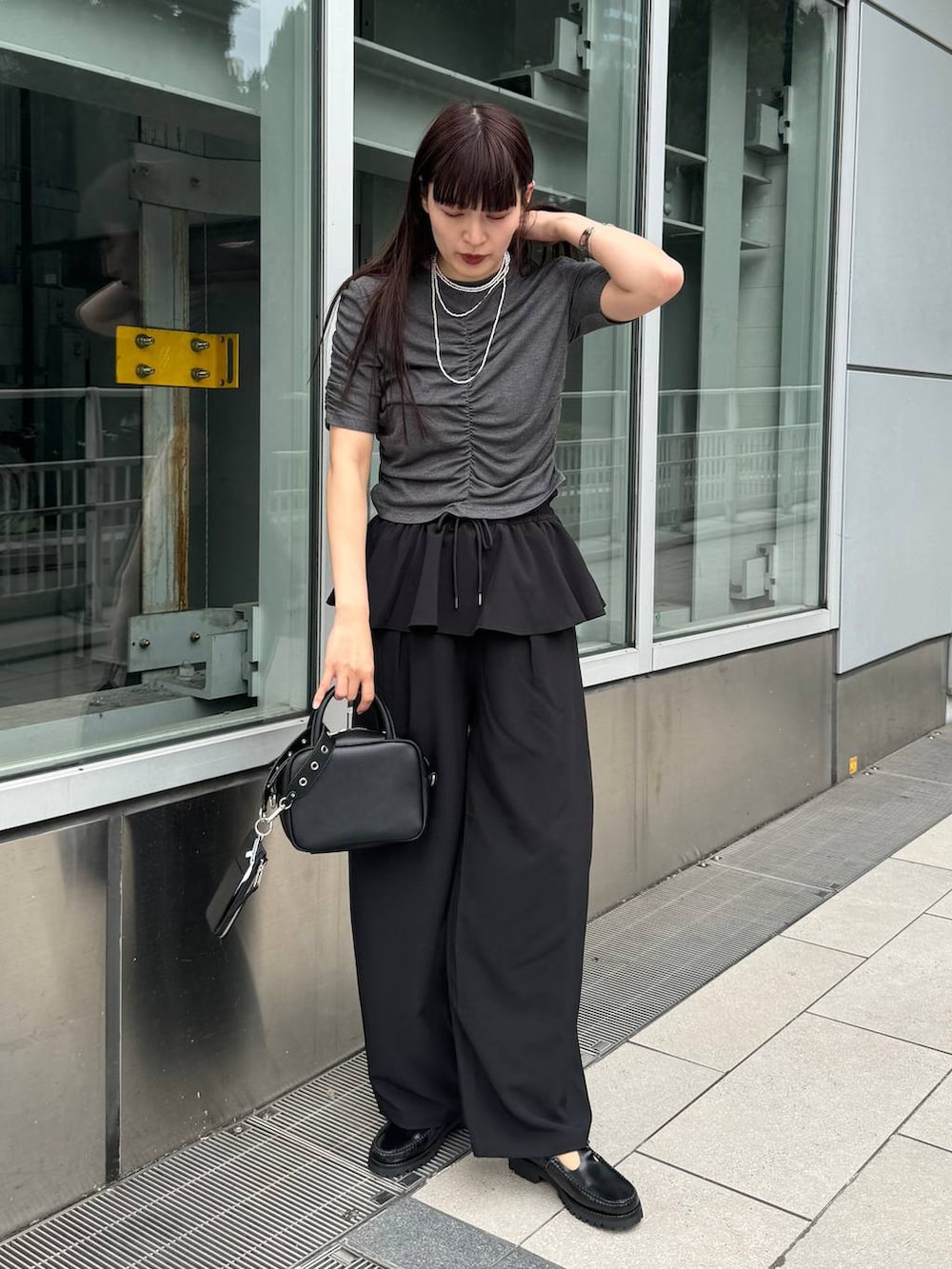 ブラック系のショルダーバッグ、グレー系のTシャツ/カットソー、ブラック系のその他パンツを着用したレディースの夏コーディネートの3枚目の写真