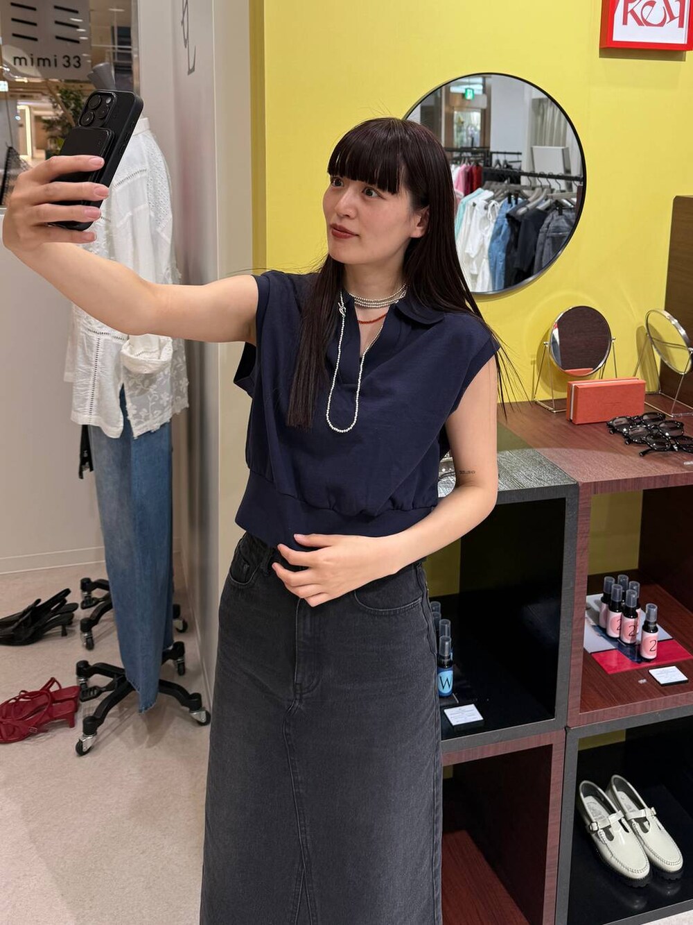 ブルー系のデニムスカート、ブラック系のサンダル、ブルー系のTシャツ/カットソーを着用したレディースの春コーディネートの7枚目の写真