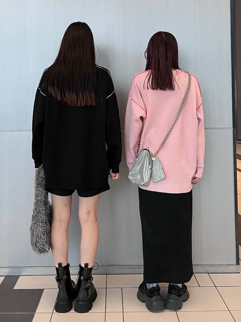 ブラック系のスカート、グレー系のハンドバッグ、ブラック系のブーツを着用したレディースの秋コーディネートの4枚目の写真