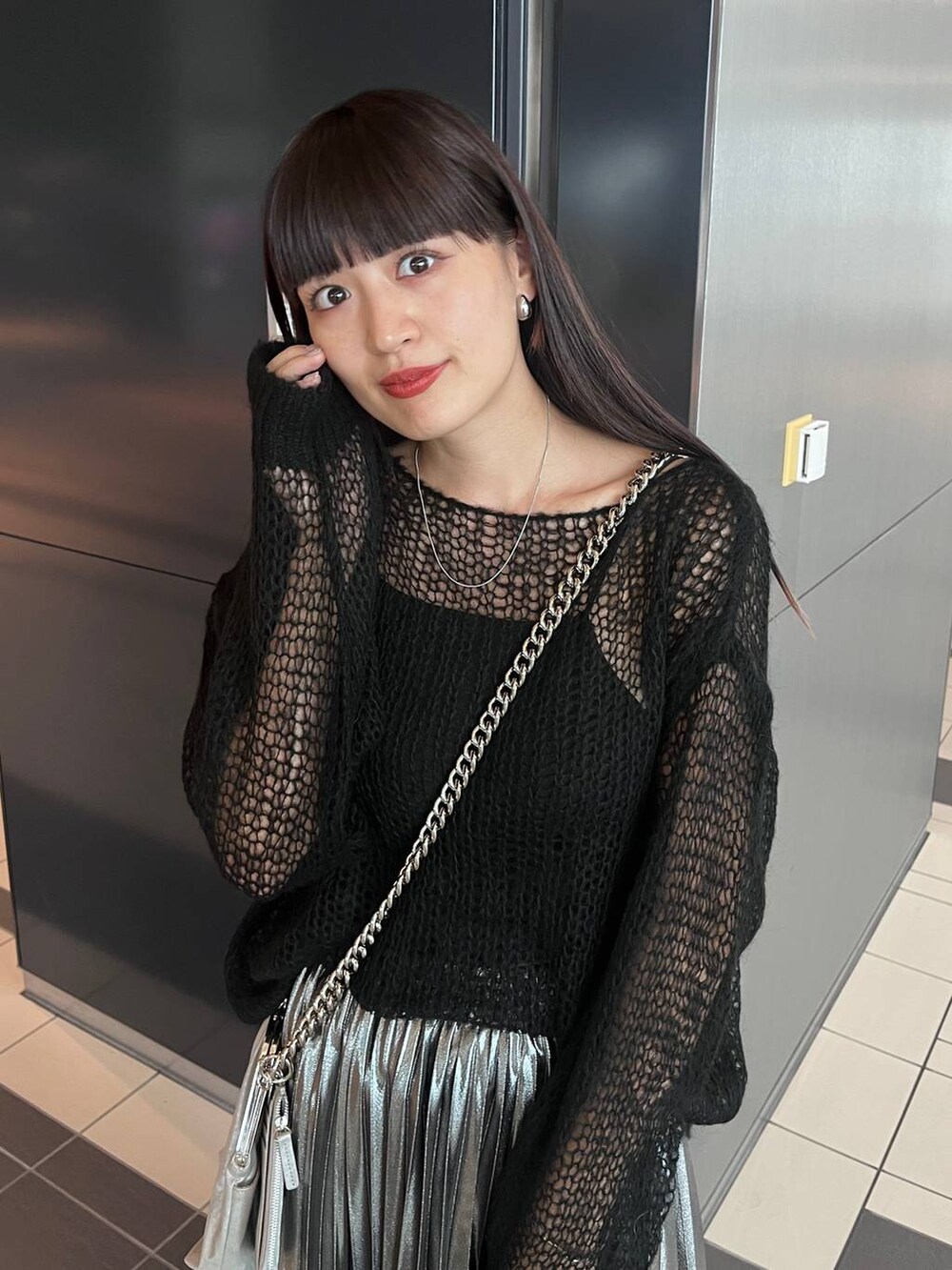 シルバー系のスカート、ブラック系のニット/セーターを着用したレディースの秋コーディネートの4枚目の写真