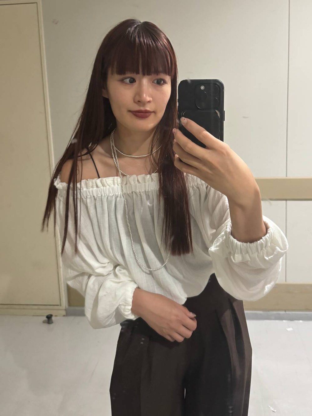 ホワイト系のシャツ/ブラウス、ブラウン系のスラックスを着用したレディースの秋コーディネートの3枚目の写真