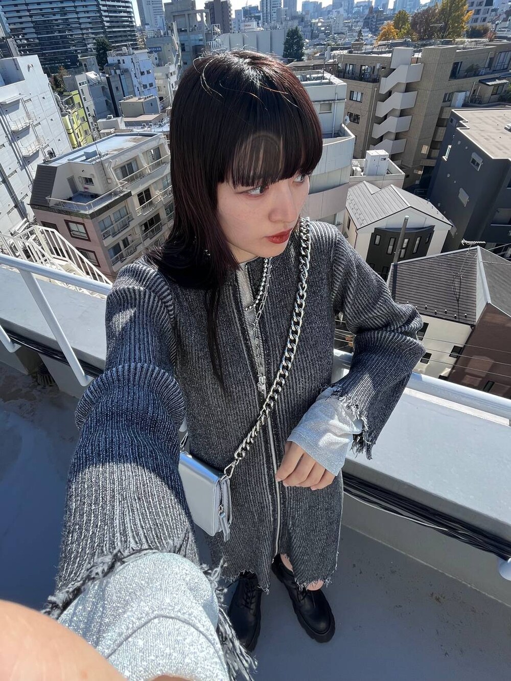 ブラック系のブーツ、ブラック系のワンピース、シルバー系のネックレスを着用したレディースの冬コーディネートの3枚目の写真