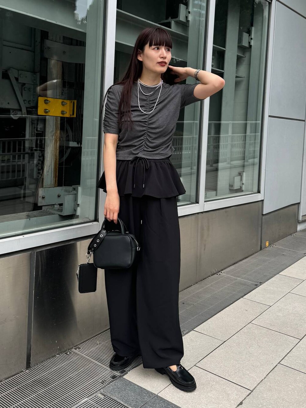 ブラック系のショルダーバッグ、グレー系のTシャツ/カットソー、ブラック系のその他パンツを着用したレディースの夏コーディネートの2枚目の写真