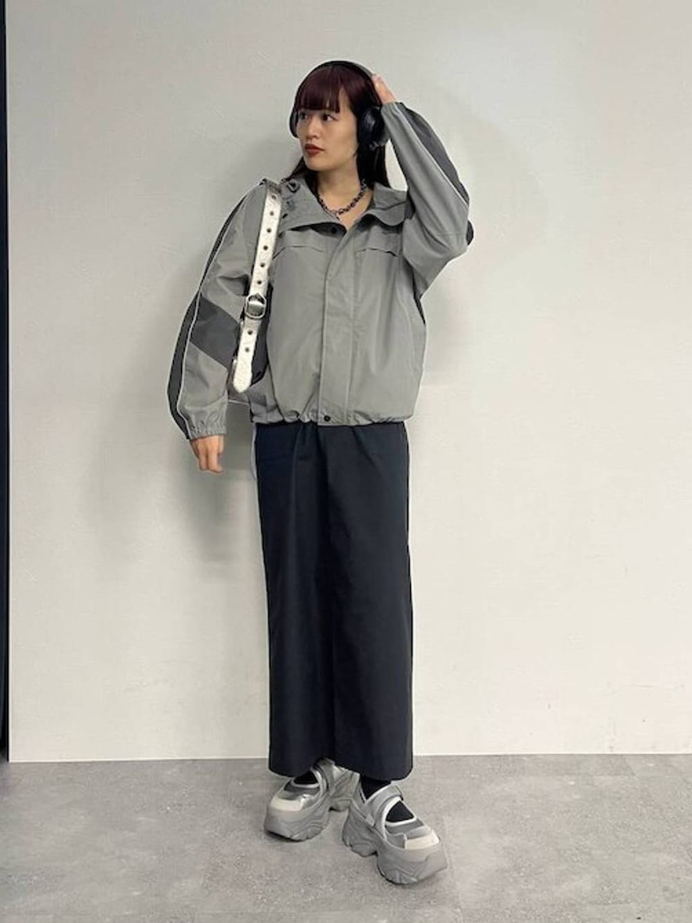 シルバー系のスニーカー、シルバー系のショルダーバッグ、ブラック系のセットアップを着用したレディースの秋コーディネートの5枚目の写真