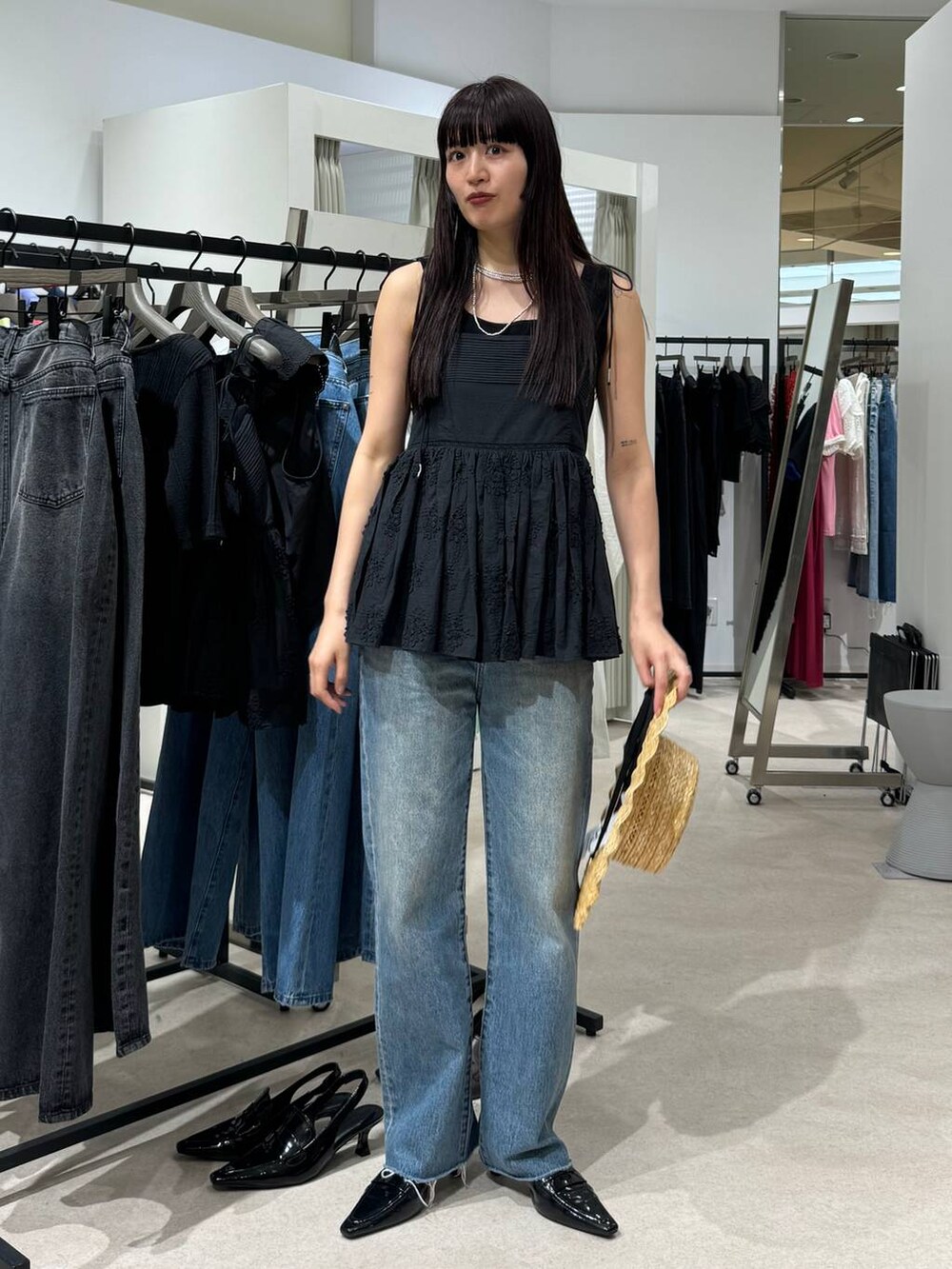 ブラウン系のローファー、ブルー系のデニムパンツ、ブラック系のキャミソールを着用したレディースの春コーディネートの5枚目の写真