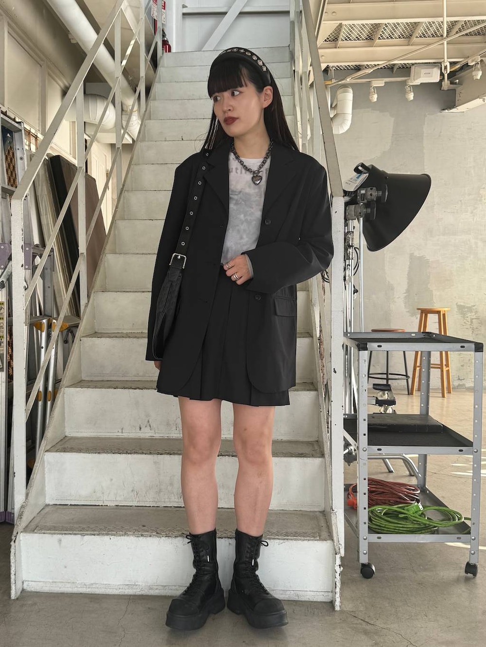 ブラック系のブーツ、ブラック系のショルダーバッグ、グレー系のTシャツ/カットソーを着用したレディースの冬コーディネートの2枚目の写真
