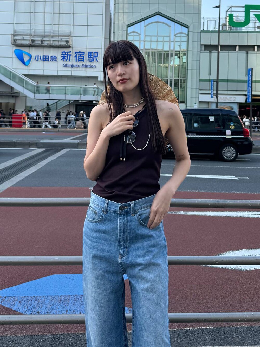 ブラック系のローファー、ブルー系のデニムパンツ、ブラウン系のタンクトップを着用したレディースの春コーディネートの2枚目の写真