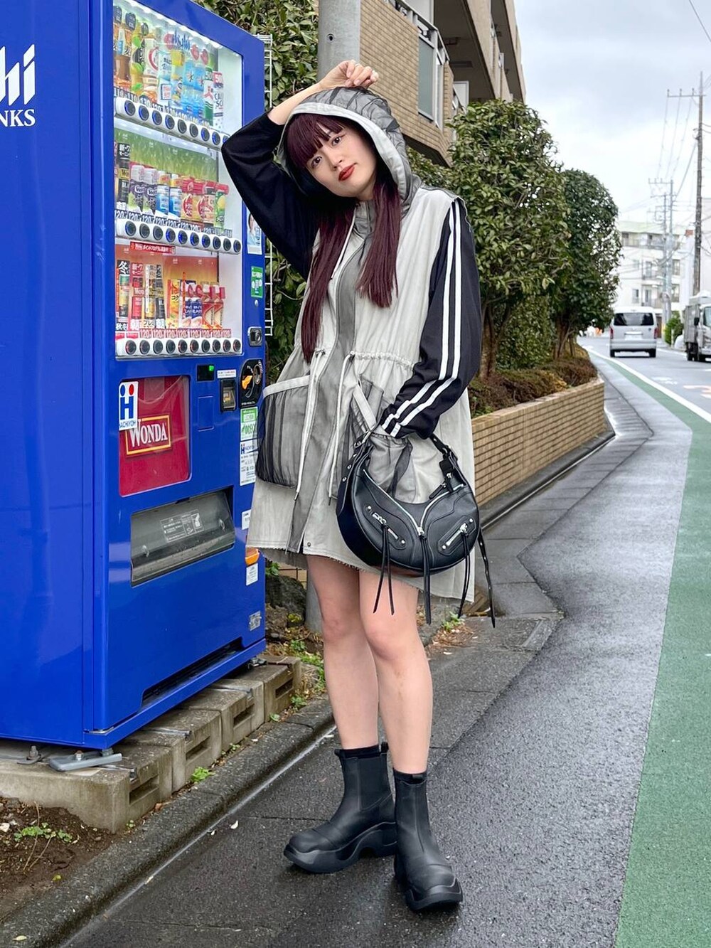 ブラック系のショルダーバッグ、ブラック系のTシャツ/カットソー、ブラック系のブーツを着用したレディースの冬コーディネートの3枚目の写真