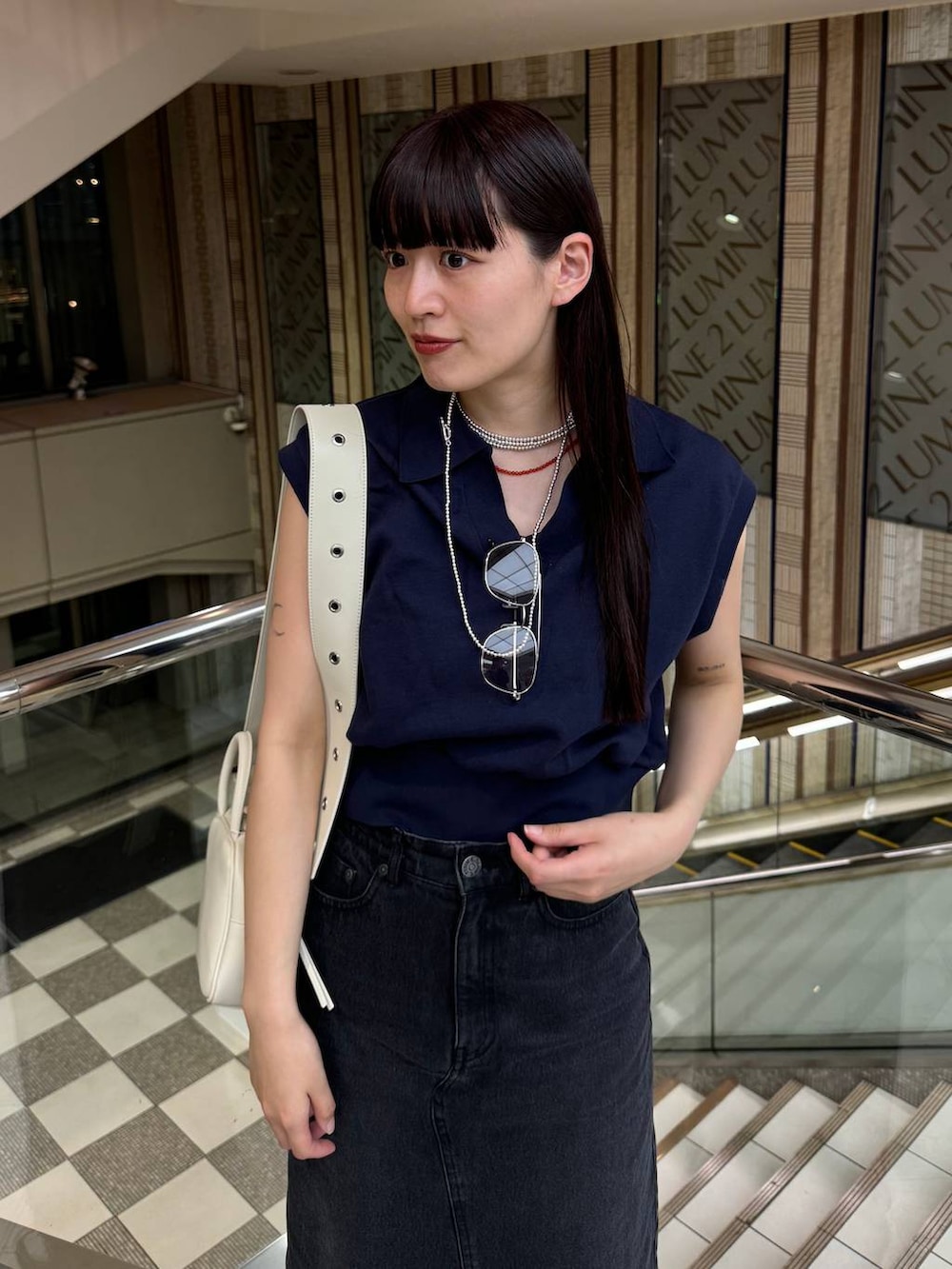 ブルー系のデニムスカート、ブラック系のサンダル、ブルー系のTシャツ/カットソーを着用したレディースの春コーディネートの6枚目の写真