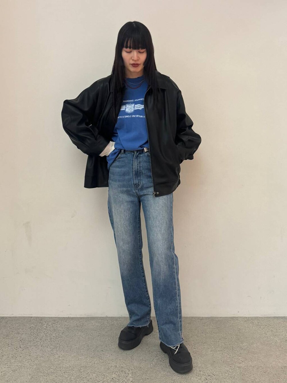 ブラック系のブルゾン、ブルー系のデニムパンツ、ブルー系のTシャツ/カットソーを着用したレディースの冬コーディネートの6枚目の写真