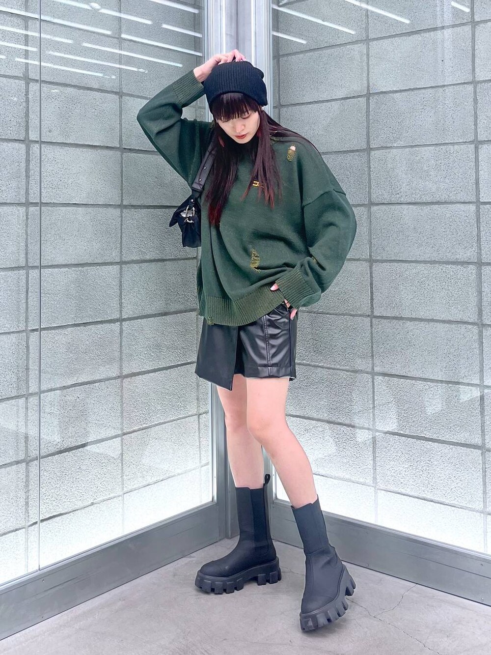 ブラック系のブーツ、ブラック系のその他パンツ、グリーン系のニット/セーターを着用したレディースの秋コーディネートの4枚目の写真