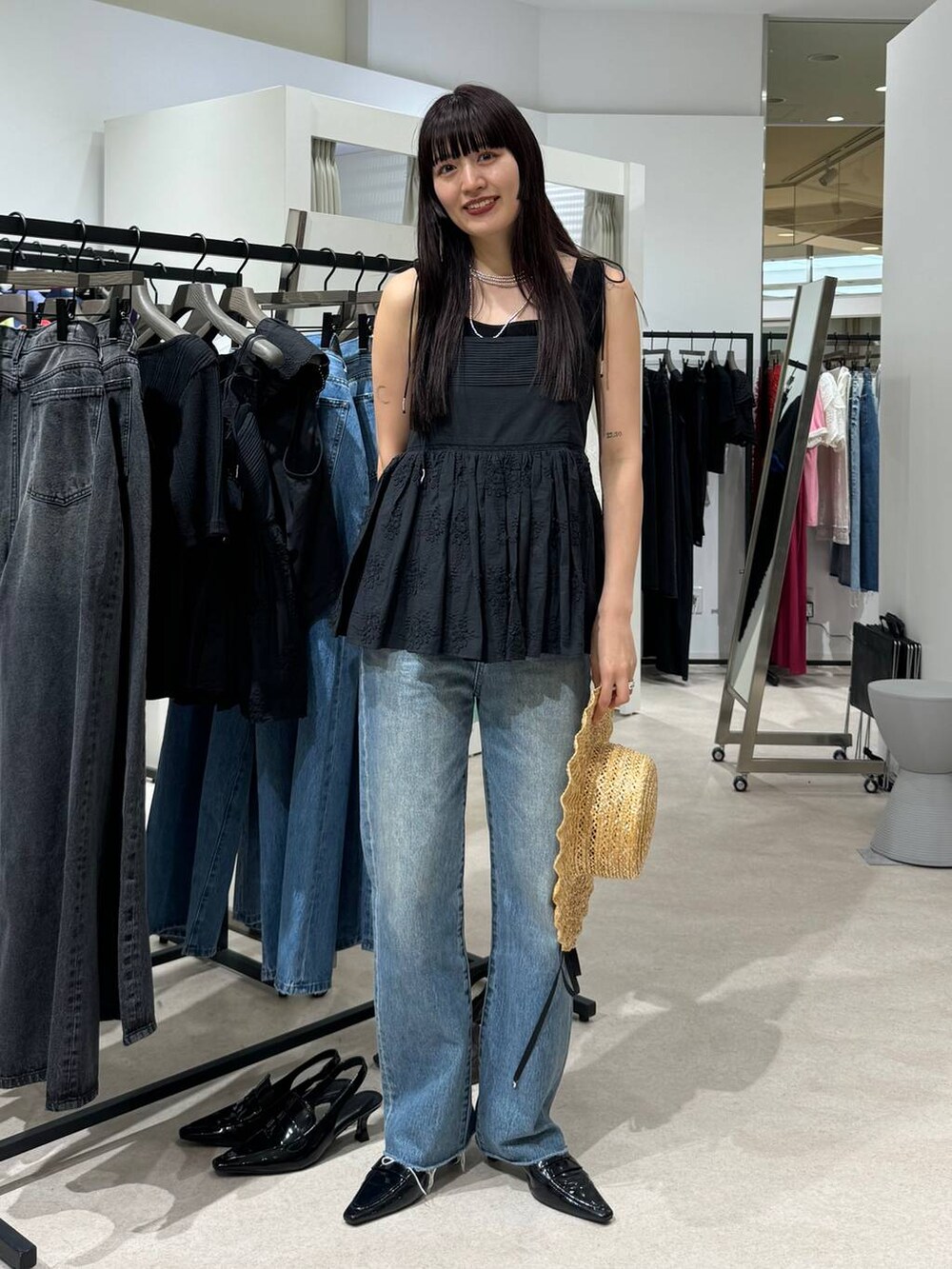 ブラウン系のローファー、ブルー系のデニムパンツ、ブラック系のキャミソールを着用したレディースの春コーディネートの2枚目の写真