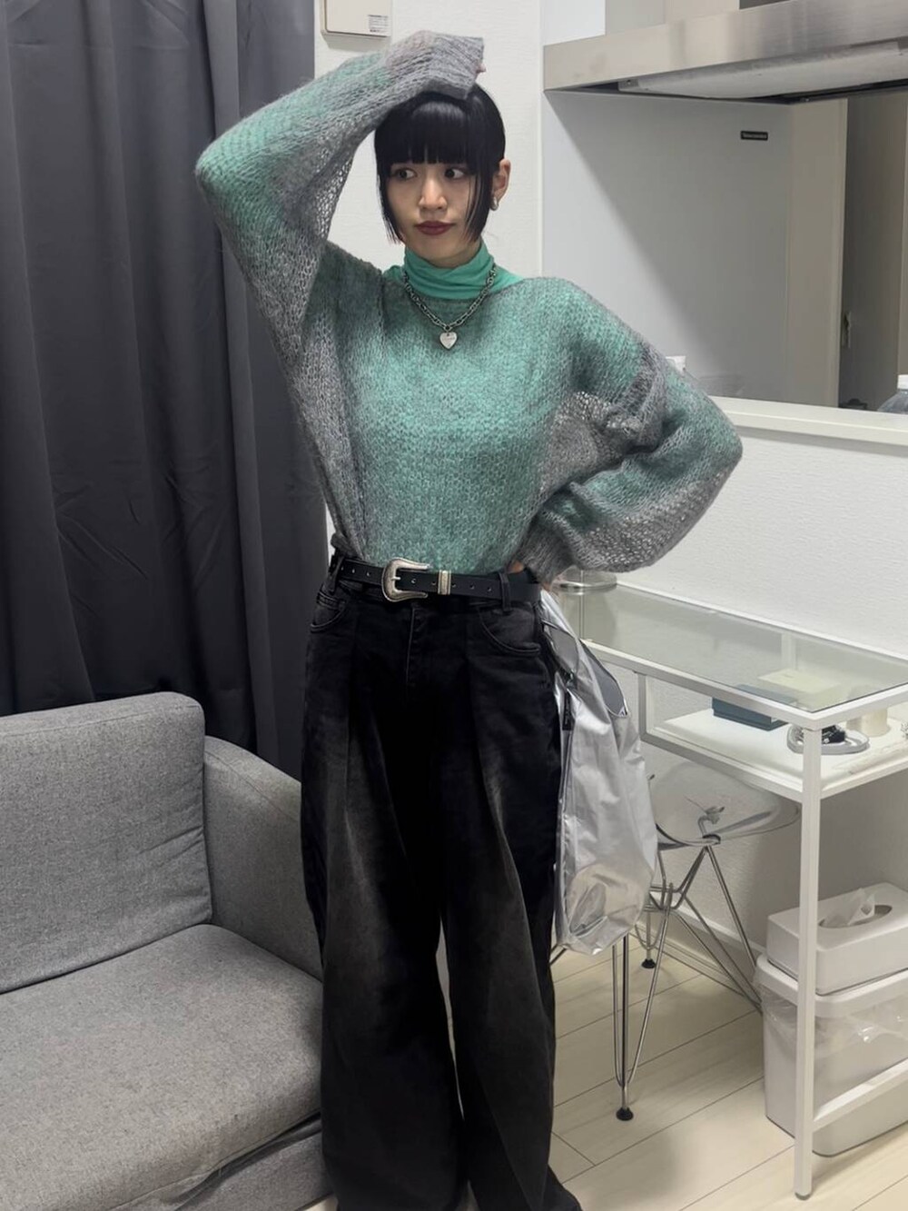 ブラック系のデニムパンツ、グレー系のニット/セーター、シルバー系のネックレスを着用したレディースの秋コーディネートの2枚目の写真