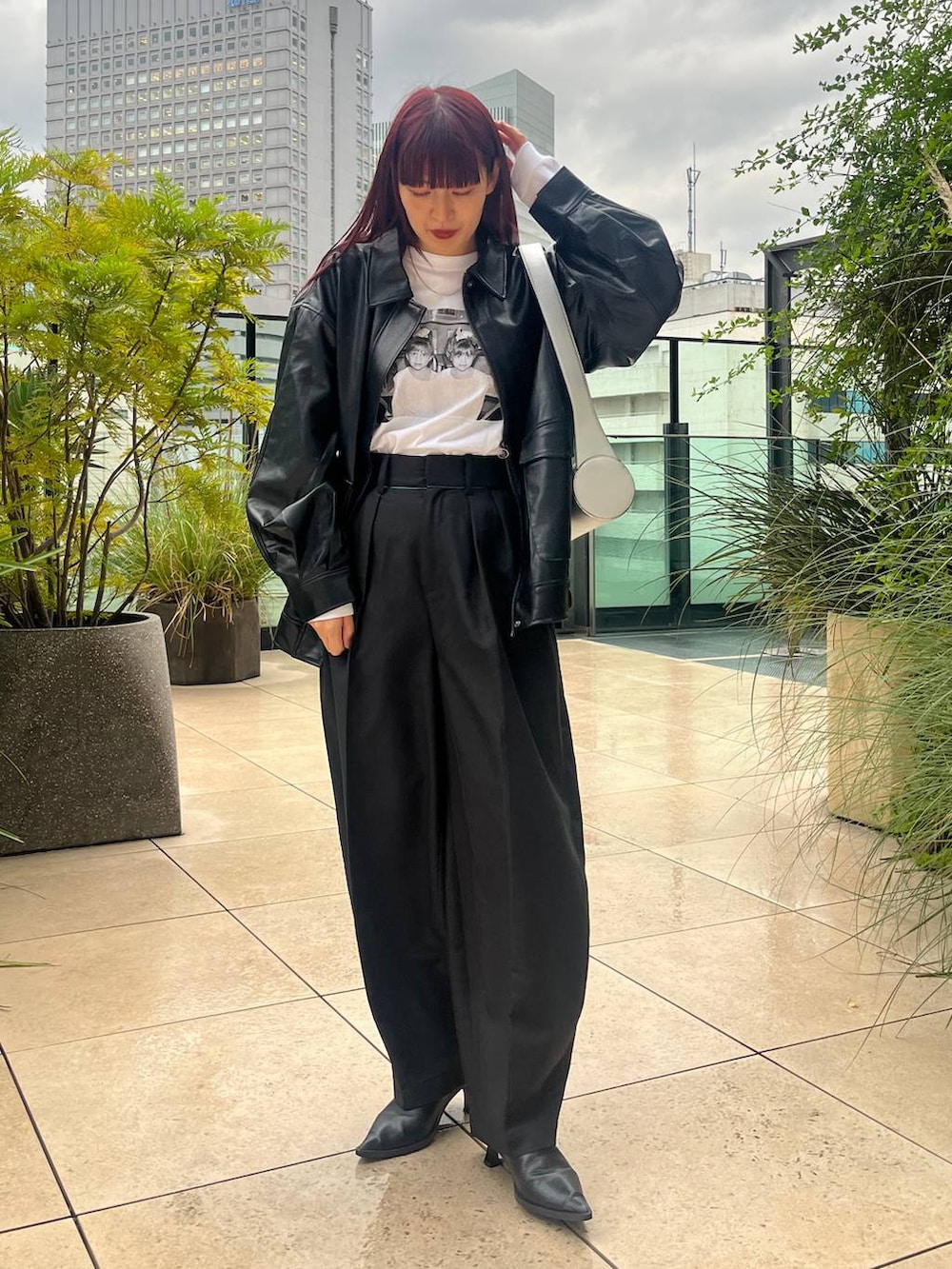 ブラック系のブルゾン、シルバー系のショルダーバッグを着用したレディースの秋コーディネートの3枚目の写真