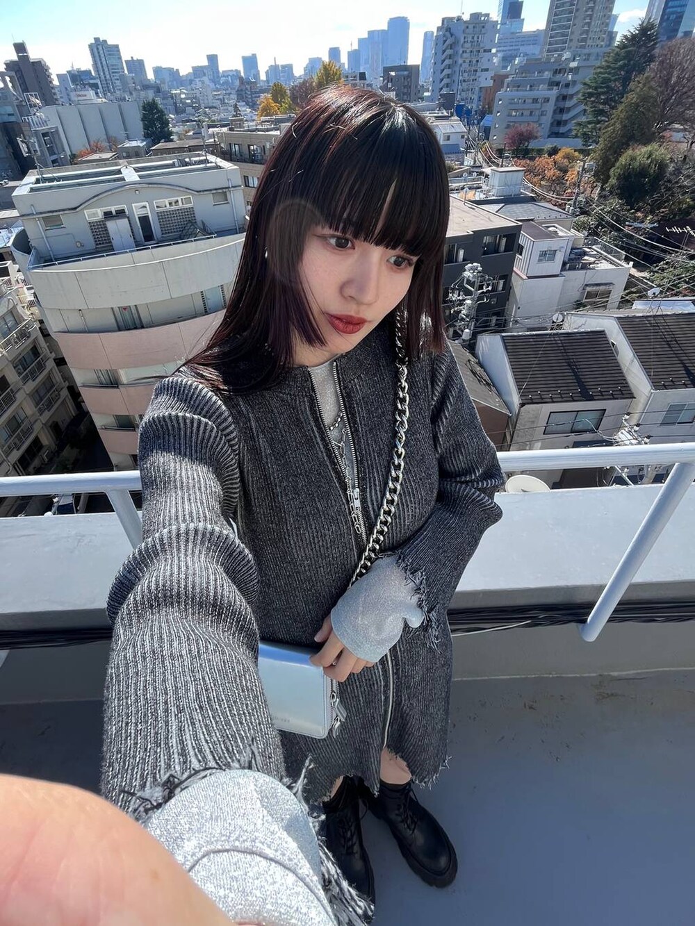 ブラック系のブーツ、ブラック系のワンピース、シルバー系のネックレスを着用したレディースの冬コーディネートの4枚目の写真