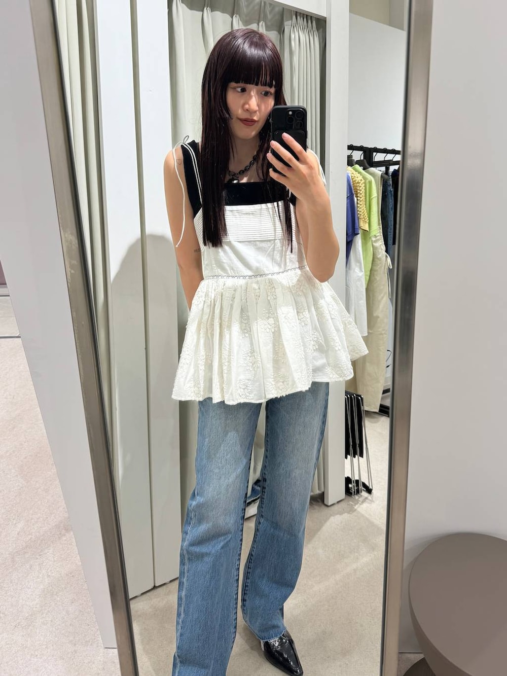 ホワイト系のキャミソール、ブルー系のデニムパンツを着用したレディースの春コーディネートの3枚目の写真