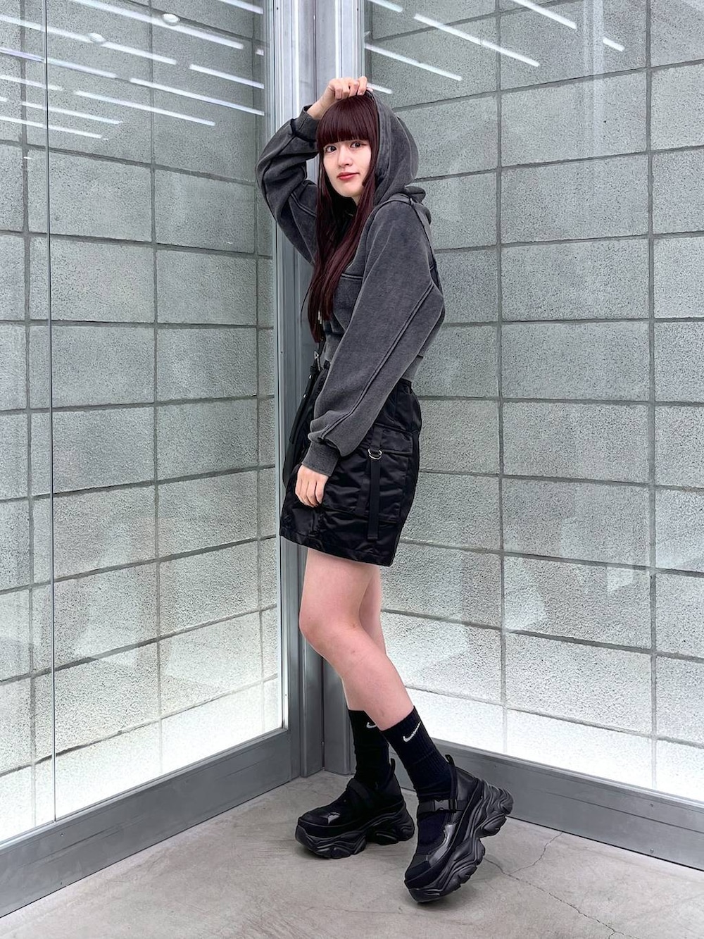 ブラック系のスカート、ブラック系のショルダーバッグ、ブラック系のパーカーを着用したレディースの冬コーディネートの4枚目の写真