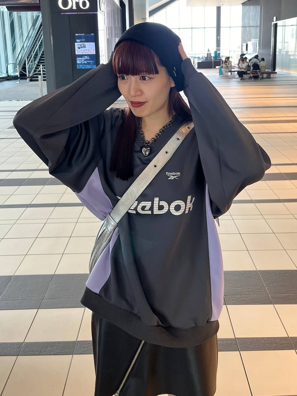 シルバー系のスニーカー、シルバー系のショルダーバッグ、グレー系のスウェットを着用したレディースの秋コーディネートの3枚目の写真