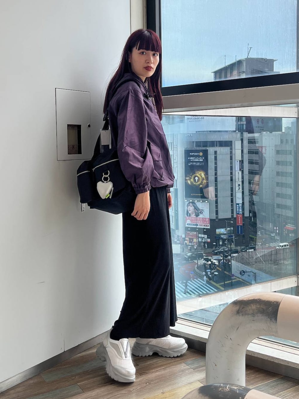 ブラック系のショルダーバッグ、ホワイト系のスニーカー、パープル系のパーカーを着用したレディースの秋コーディネートの3枚目の写真