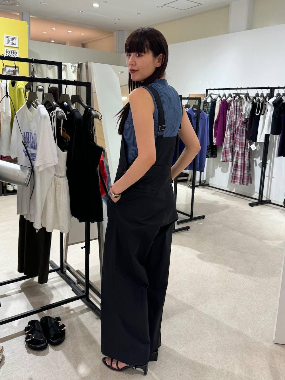 ブラック系のサンダル、ブルー系のニット/セーター、ブラック系のサロペット/オーバーオールを着用したレディースの夏コーディネートの2枚目の写真