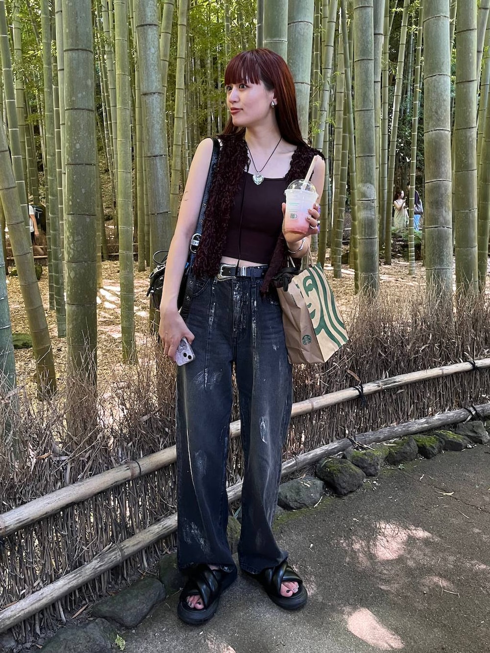 ブラック系のベスト、ブラック系のデニムパンツを着用したレディースの夏コーディネートの4枚目の写真