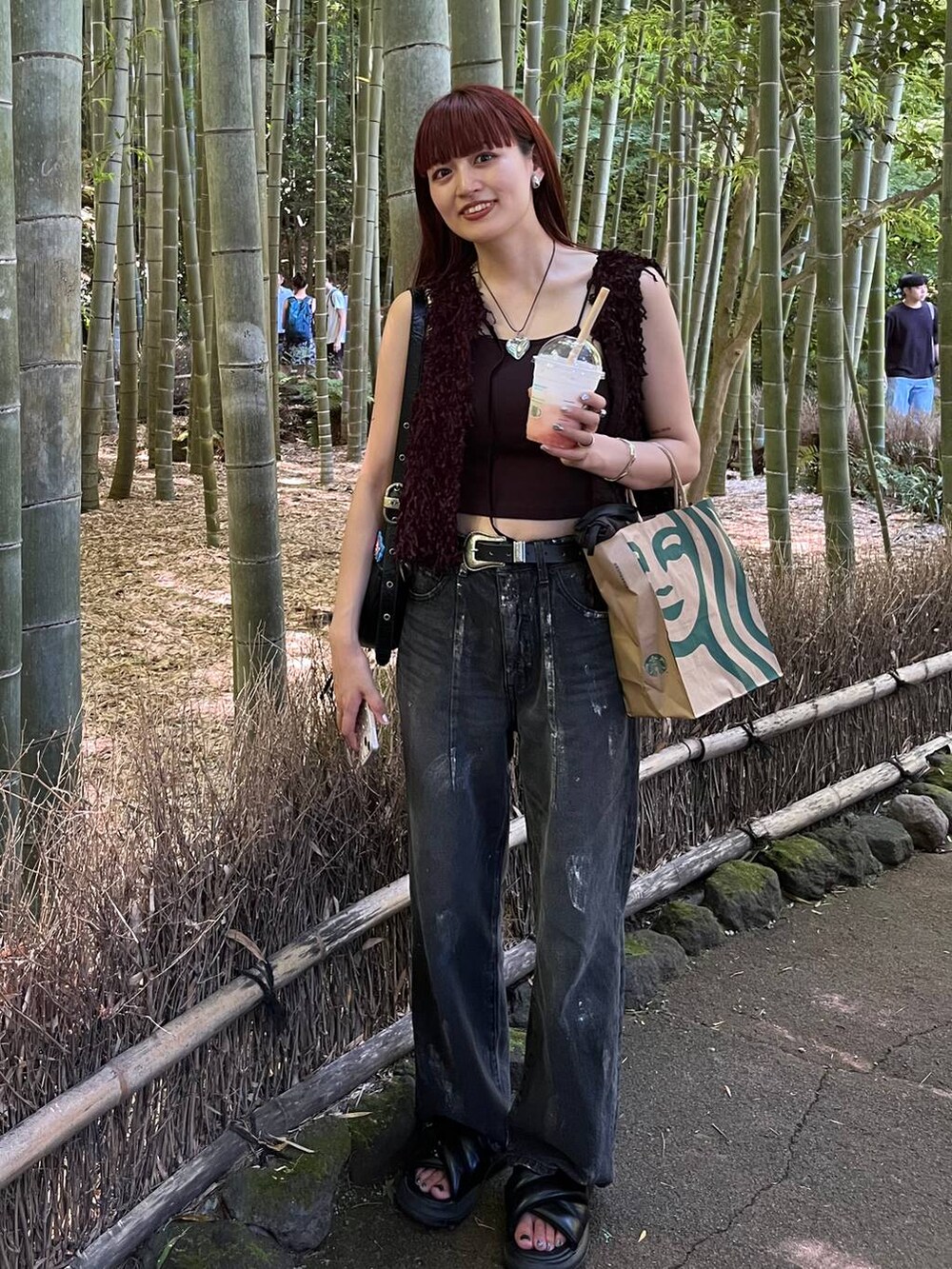 ブラック系のベスト、ブラック系のデニムパンツを着用したレディースの夏コーディネートの5枚目の写真