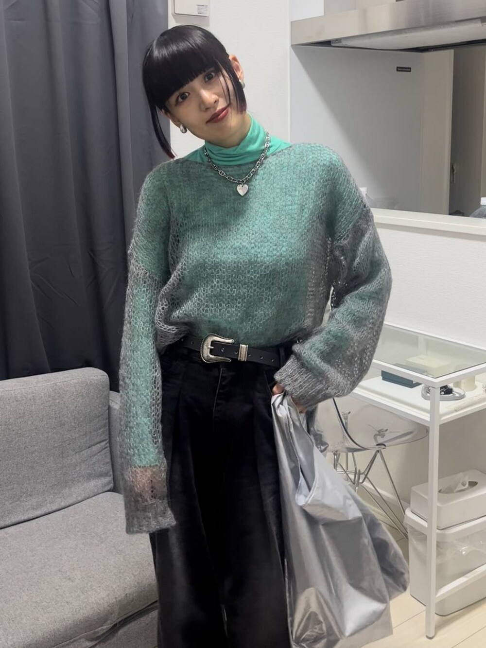 ブラック系のデニムパンツ、グレー系のニット/セーター、シルバー系のネックレスを着用したレディースの秋コーディネートの3枚目の写真