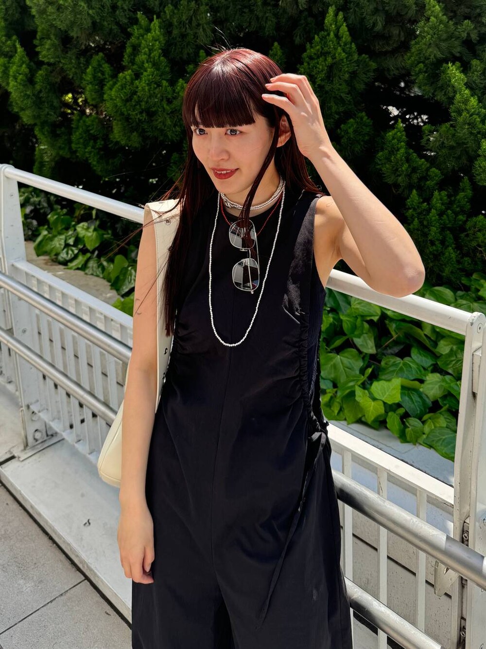 ホワイト系のショルダーバッグ、ブラック系のサロペット/オーバーオール、ブラック系のサンダルを着用したレディースの春コーディネートの5枚目の写真