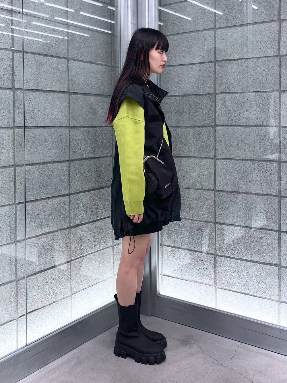 グリーン系のニット/セーター、ブラック系のショルダーバッグ、ブラック系のミリタリージャケットを着用したレディースの秋コーディネートの4枚目の写真