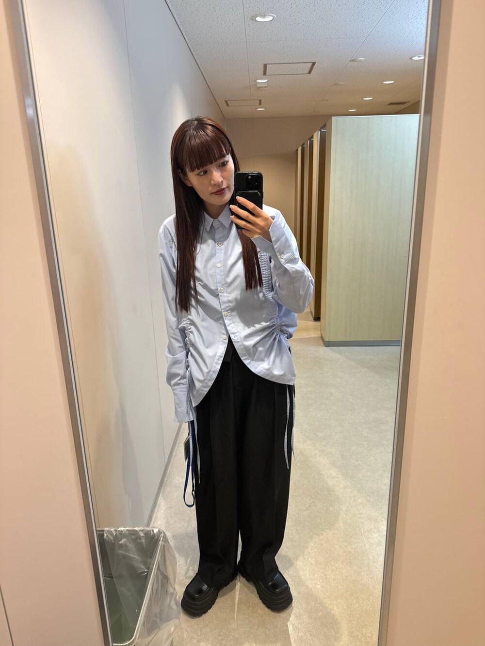 ブルー系のシャツ/ブラウス、ブラック系のスラックスを着用したレディースの秋コーディネートの4枚目の写真