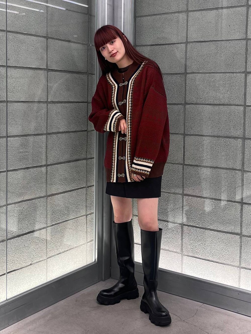 ブラウン系のカーディガン/ボレロ、ブラック系のスカート、ブラック系のブーツを着用したレディースの夏コーディネートの2枚目の写真