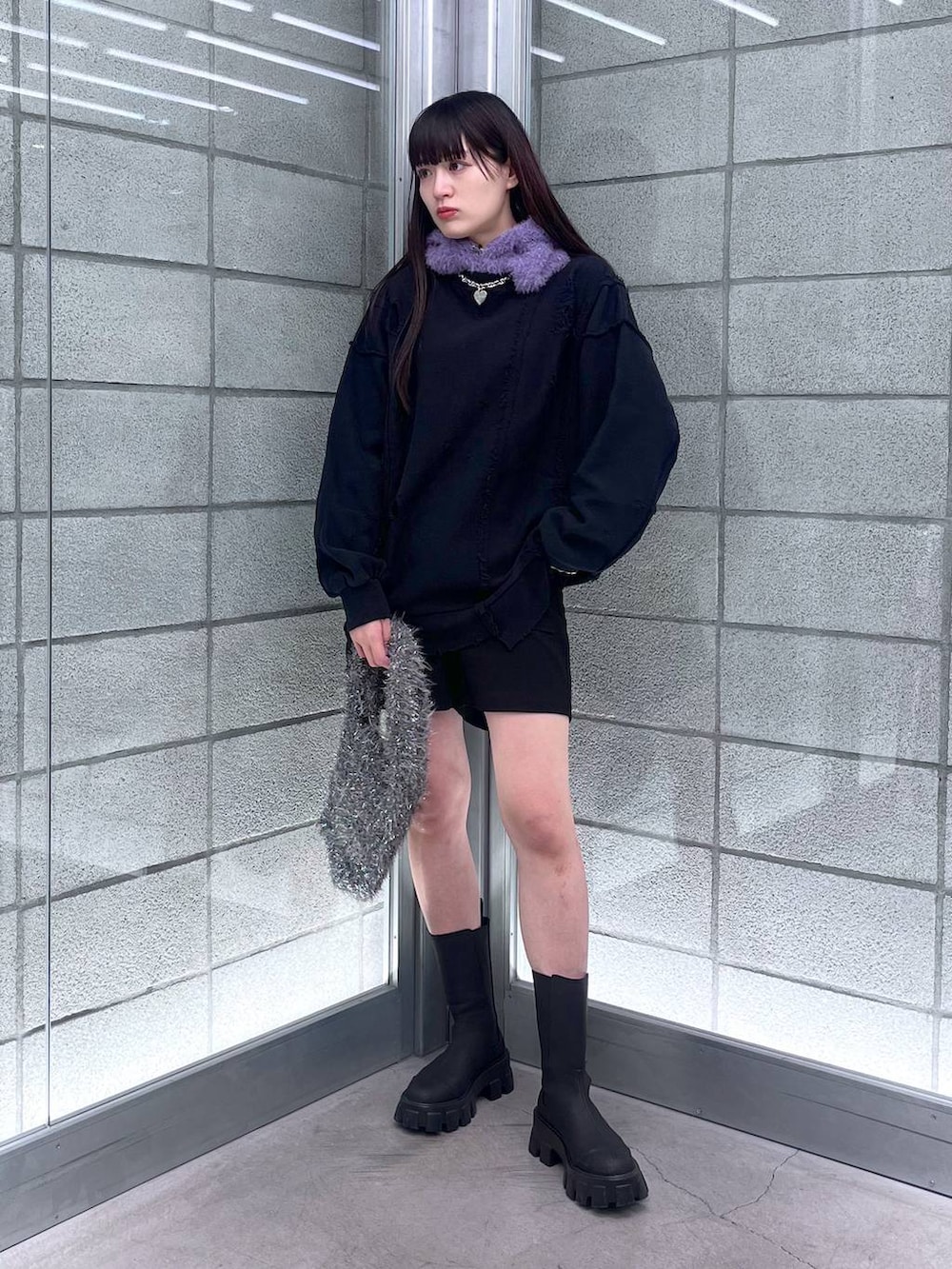 グレー系のハンドバッグ、ブラック系のスウェット、シルバー系のネックレスを着用したレディースの冬コーディネートの6枚目の写真