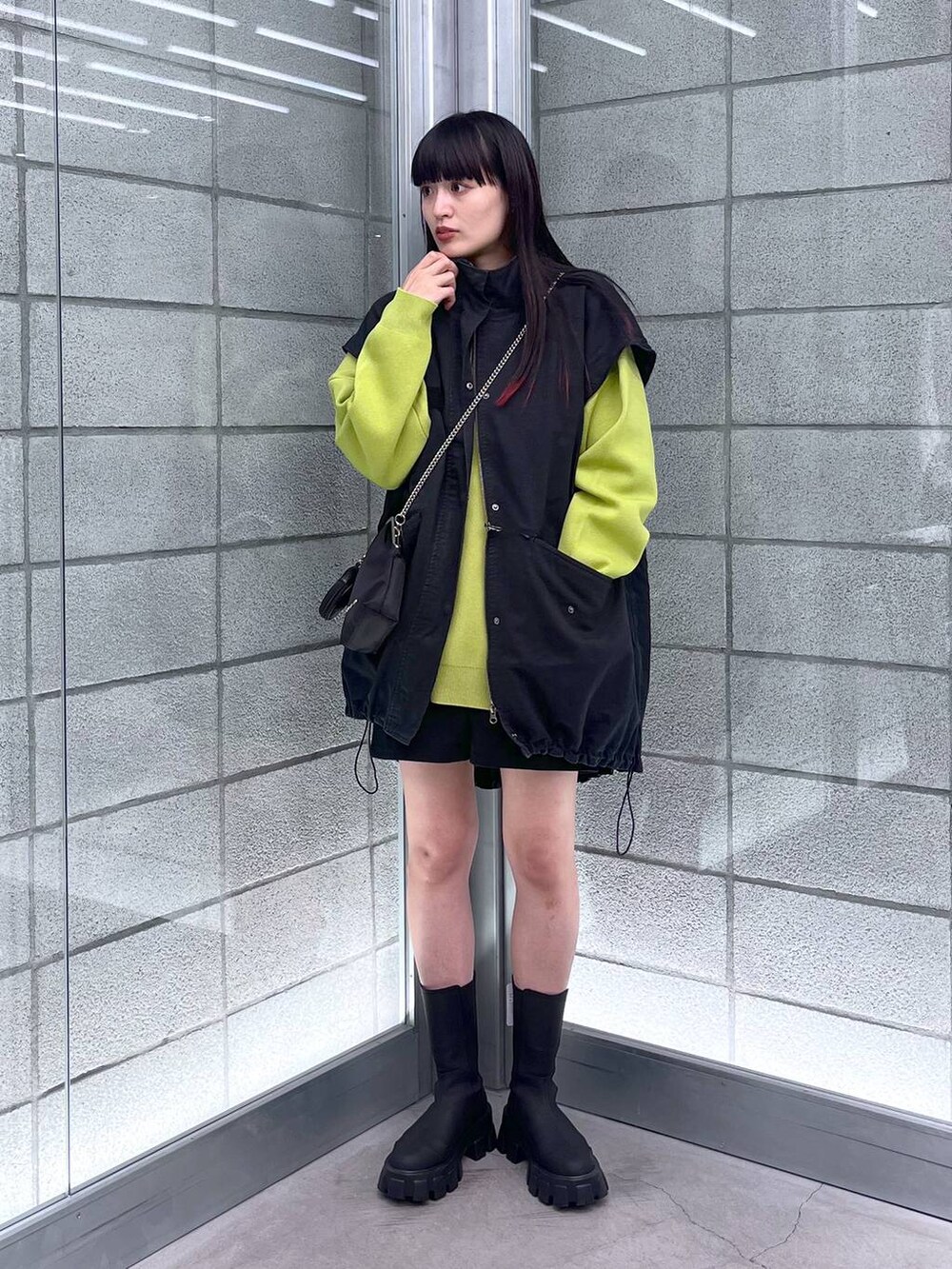 グリーン系のニット/セーター、ブラック系のショルダーバッグ、ブラック系のミリタリージャケットを着用したレディースの秋コーディネートの2枚目の写真