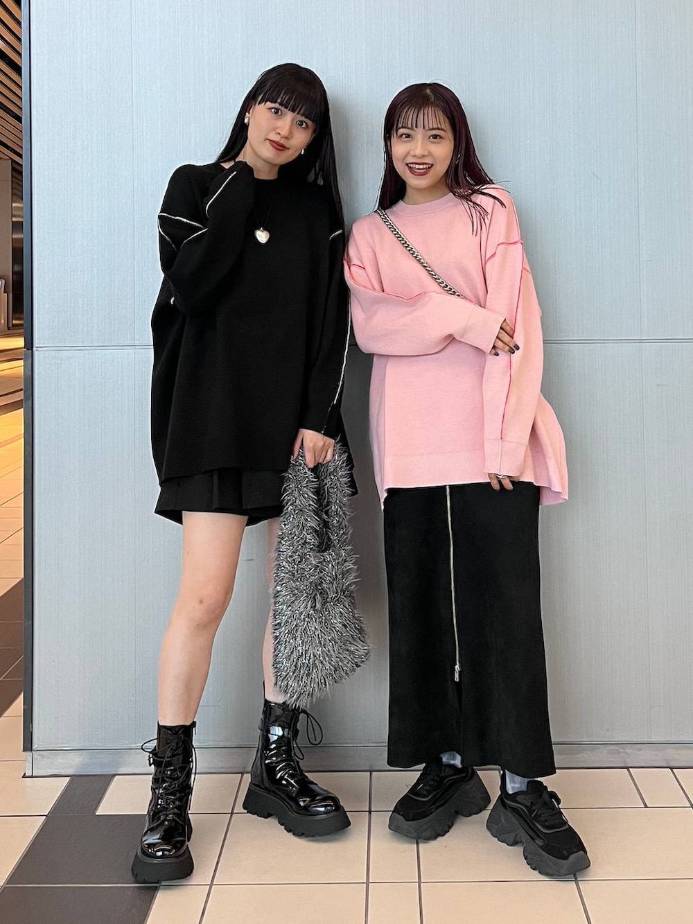 ブラック系のスカート、グレー系のハンドバッグ、ブラック系のブーツを着用したレディースの秋コーディネートの2枚目の写真