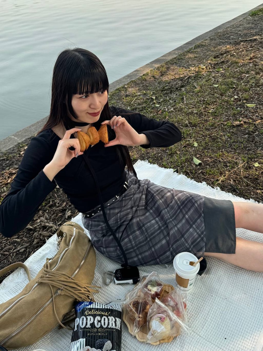 グリーン系のブーツ、ブラック系のスカート、ベージュ系のショルダーバッグを着用したレディースの春コーディネートの5枚目の写真