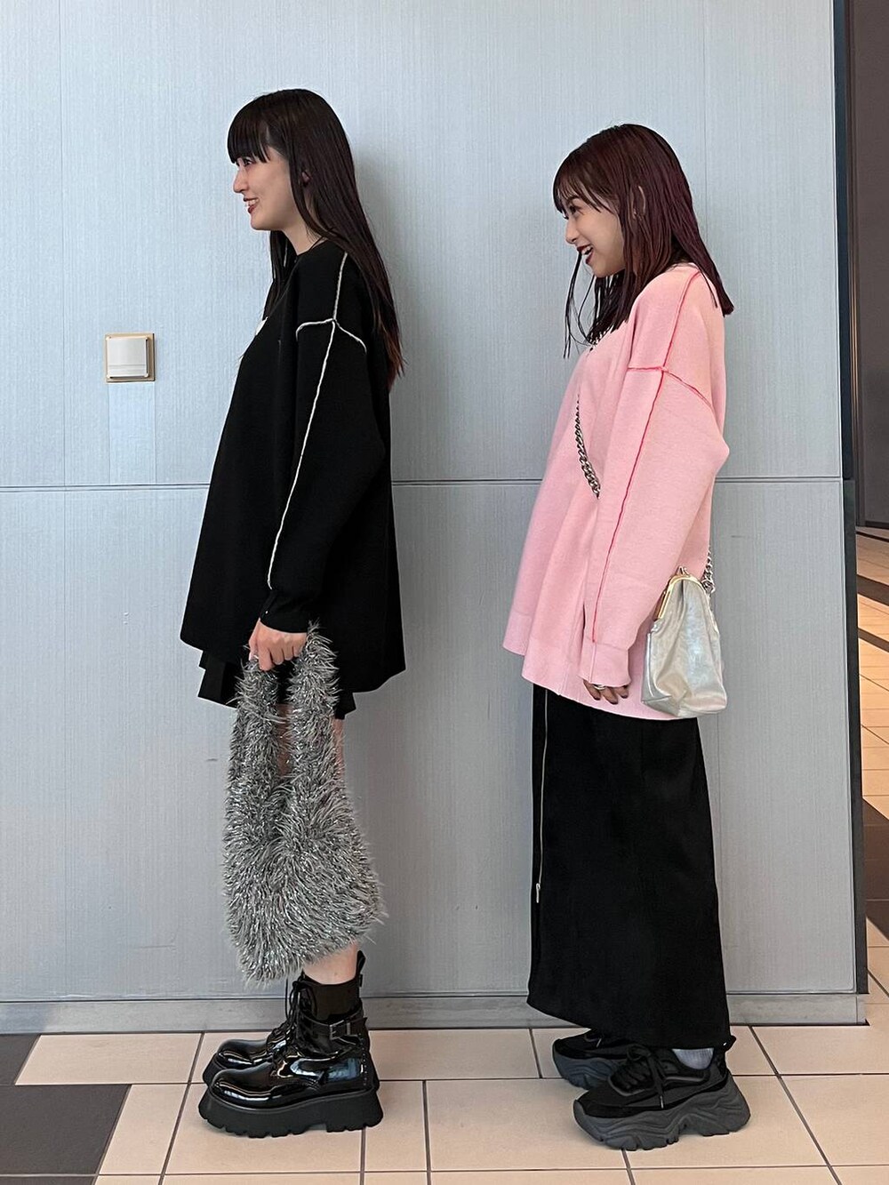 ブラック系のスカート、グレー系のハンドバッグ、ブラック系のブーツを着用したレディースの秋コーディネートの5枚目の写真