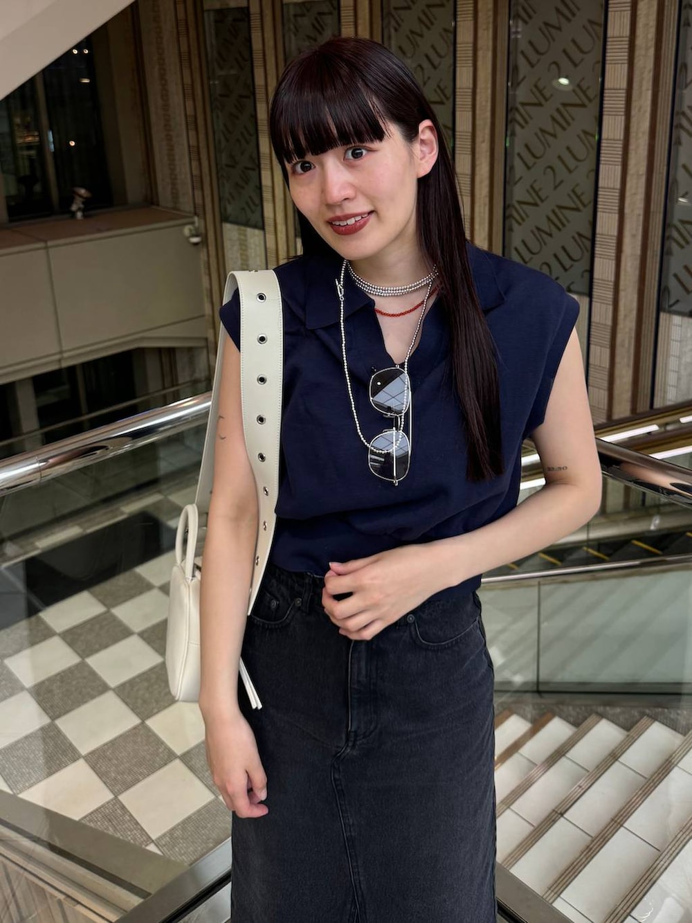 ブルー系のデニムスカート、ブラック系のサンダル、ブルー系のTシャツ/カットソーを着用したレディースの春コーディネートの4枚目の写真